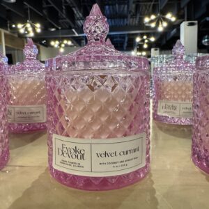 A pink glass jar candle labeled velvet cotton.
